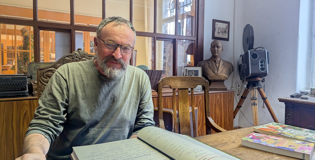 Helmut Zahn vor dem neu aufgelegten Gästebuch. Im Hintergrund die Büste von Helmut Späth.