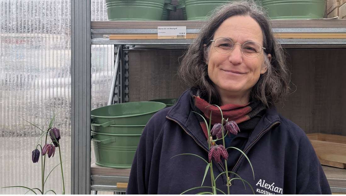 Dagmar Hauke, Gärtnermeisterin in der Alexianer Klostergärtnerei mit Schachbrettblume, Neophyt und durch die Bundesartenschutzverordnung besonders geschützt.